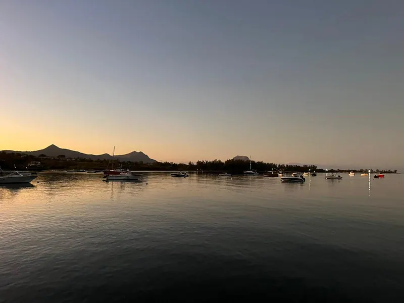 La baie de Rivière Noire au crépuscule, bateaux au mouillage