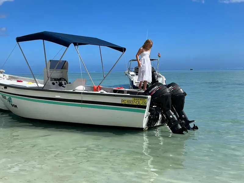 FreeDom ancré dans le lagon turquoise, une passagère debout à l’avant